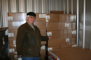 Richard Cooper, the executive Director of Harrison County Community Services shows off a portion of the 100 cases of chicken donated by Tyson in the HCCS freezer.